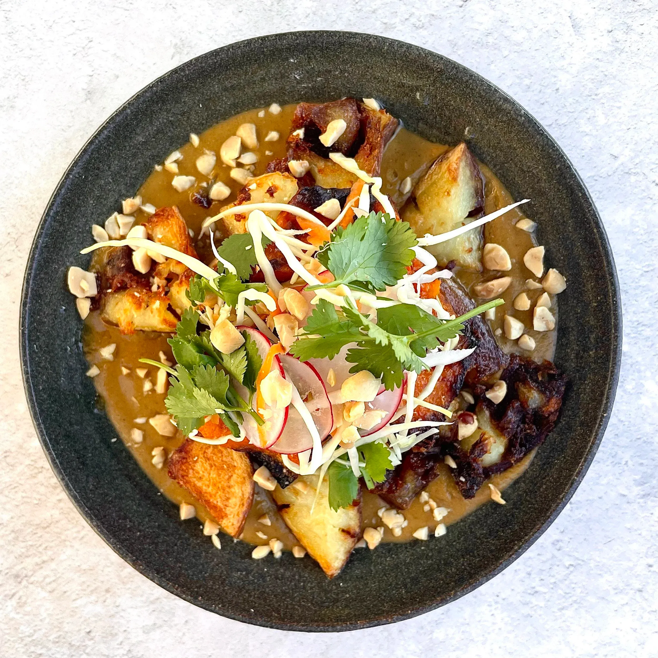 Roast root vegetables on peanut sauce with radish and Chinese cabbage salad